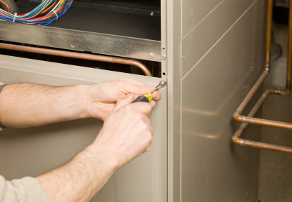 Close view of technician's hands opening a furnace.